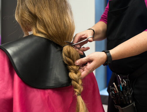 Quero-ajudar-pessoas-necessitadas-2 imagem de uma voluntária tendo o cabelo cortado por uma cabeleireira simulando doar os cabelos para ajudar pessoas necessitadas