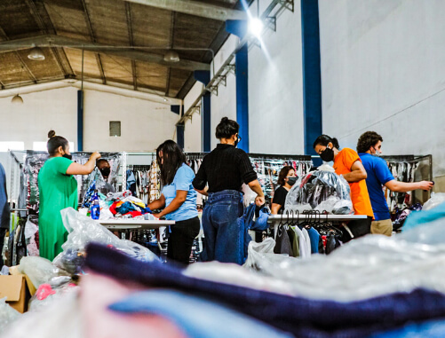 Quero-ajudar-pessoas-necessitadas-5 imagem de um grupo de pessoas embalando roupas para ajudar pessoas necessitadas