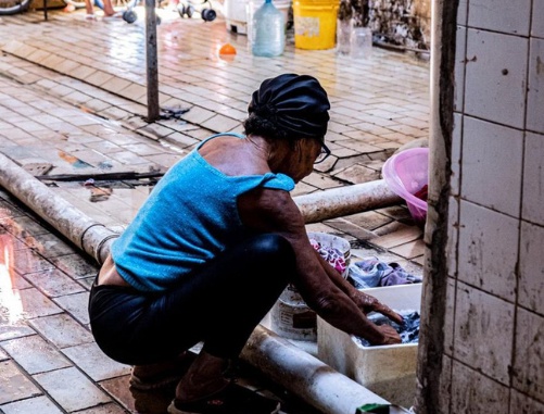 mulher lavando roupas no chão 