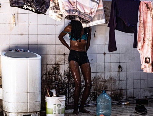 Jovem tomando banho em local sujo e vulnerável